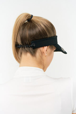 Black ladies golf visor constructed with quick-drying fabrics. The visor comes in a one size fits all design with an elasticated cord at the rear to hold it securely in place. It also features a concealed magnet  in peak with a hand enamelled lace golf ball marker attached, making it a lovely golf accessory, golf gift! The headband features a soft lined absorbent towel. 
